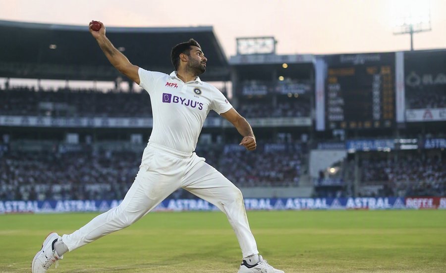 Bowler in white kit delivering a ball on the pitch